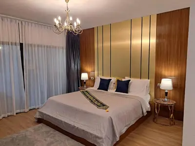 a bedroom with a large bed and a chandelier at The Chic Pool Villa in Nai Yang Beach