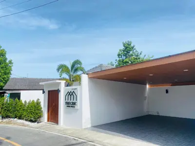 a white building with a sign on the side of it at The Chic Pool Villa in Nai Yang Beach