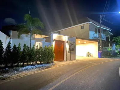 a house on a street at night at The Chic Pool Villa in Nai Yang Beach
