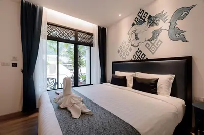 a bedroom with a large bed with a pair of shoes on it at Sabai Hotel Aonang in Ao Nang Beach