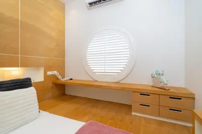 a bedroom with a round window and a wooden dresser at Villa Casa Koko - Luxury Modern Minimalism in Thalang