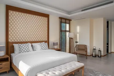 a bedroom with a large white bed and a chair at Beachfront Residences - Stunning Sea and Lake View in Bang Tao Beach