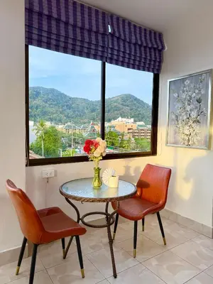 a dining room with a table and two chairs and a window at Happy Holidays - 2 Minutes to Patong Beach in Patong Beach