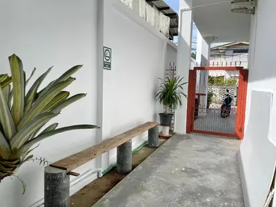 an entrance to a white building with a red door at Alleyhill Phuket - Private & Cozy Boutique in Phuket Town