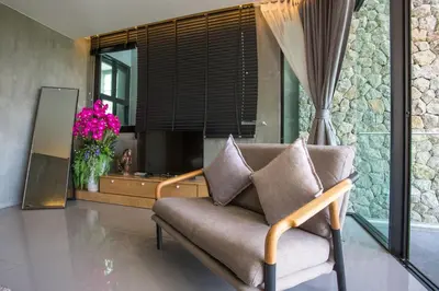 a living room with a couch and a vase of flowers at Villa Jeanne in Kamala Beach