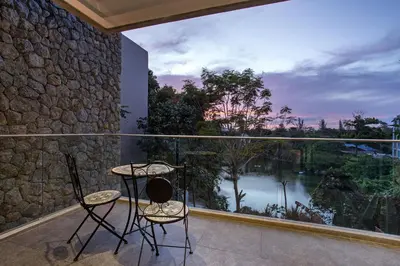 two chairs and a table on a balcony with a view at Villa Jeanne in Kamala Beach