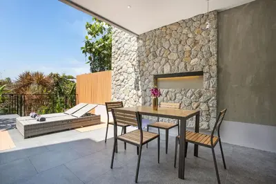 a dining room with a table and chairs on a patio at Villa Jeanne in Kamala Beach