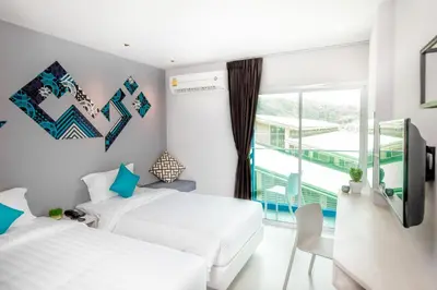 two beds in a room with a window at The Crib Patong - SHA Certified in Patong Beach