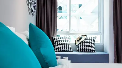 a bed with pillows and a window in a room at The Crib Patong - SHA Certified in Patong Beach