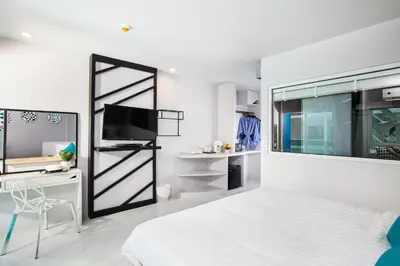 a bedroom with a bed and a desk and a tv at The Crib Patong - SHA Certified in Patong Beach
