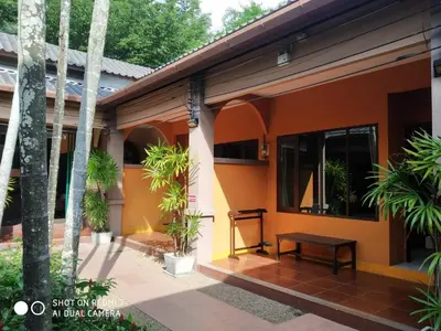 a guest house with a porch with palm trees at Phuket Siam Villas - SHA PLUS in Chalong
