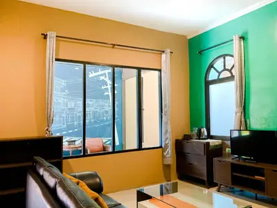 a living room with a couch and a large window at Phuket Siam Villas - SHA PLUS in Chalong