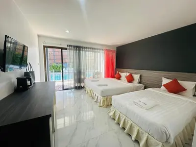 a bedroom with two beds and a large window at Machorat Aonang Resort at Aonang Beach Krabi in Ao Nang Beach