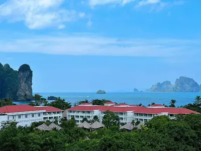 a resort with red roofs and the ocean in the background at Machorat Aonang Resort at Aonang Beach Krabi in Ao Nang Beach
