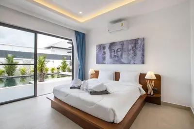 a bedroom with a large bed and a large window at amazing new brand 3 bedrooms pool villa at rawai in Rawai Beach