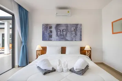a bedroom with a large white bed with two lamps at amazing new brand 3 bedrooms pool villa at rawai in Rawai Beach
