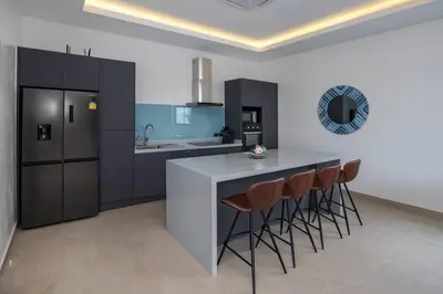 a kitchen with a counter and stools in a room at amazing new brand 3 bedrooms pool villa at rawai in Rawai Beach