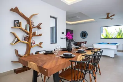 a dining room with a wooden table and chairs at amazing new brand 3 bedrooms pool villa at rawai in Rawai Beach