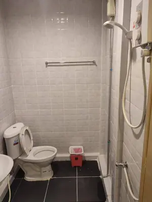 a small bathroom with a toilet and a shower at Kitty Guesthouse in Phi Phi Don
