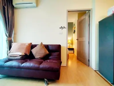 a brown leather couch sitting in a living room at Chic & Sweet, Pool view, Prime location near beach in Phuket Town