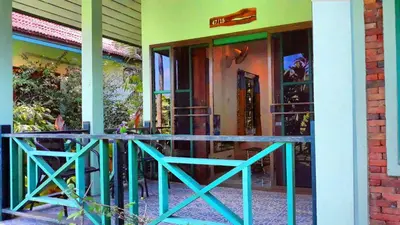 a front porch of a house with a blue railing at Swiss Chalet Garden, Pool Resort in Krabi town