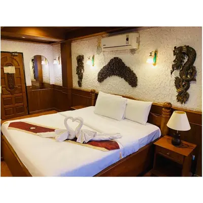 a hotel room with a bed with a ribbon on it at Grillhütte Patong in Patong Beach