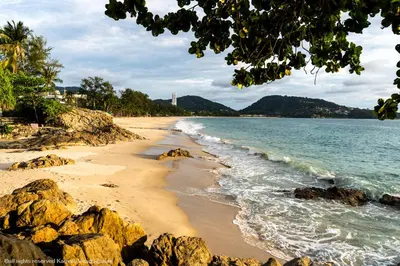 a sandy beach with rocks and the ocean at Grillhütte Patong in Patong Beach