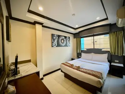 a bedroom with a bed and a desk and a television at Hill View Lodge in Patong Beach