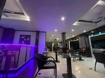 a dining room with purple lighting and tables and chairs at Hill View Lodge in Patong Beach