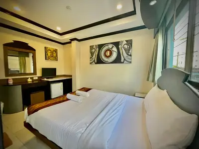 a bedroom with a bed with two towels on it at Hill View Lodge in Patong Beach