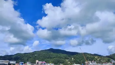 a cloudy sky with a mountain in the background at Hill View Lodge in Patong Beach