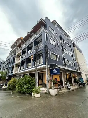 a large gray building on the corner of a street at Hill View Lodge in Patong Beach