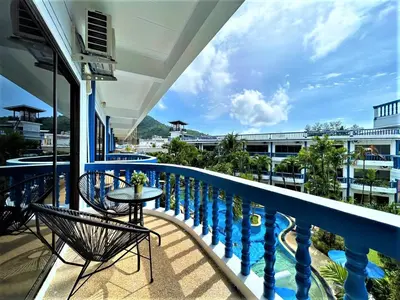 a balcony with a table and chairs and a pool at Kamala - The Club Residence -2 BR Pool View Residence in Kamala Beach