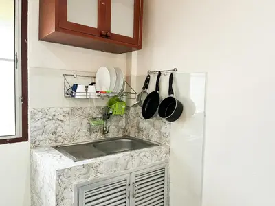 a kitchen with a sink and a counter with pots and pans at 1BR Cozy House, Bangtao Beach in Ban Thalat Choeng Thale