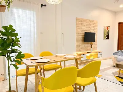 a dining room with a table and yellow chairs at 1BR Cozy House, Bangtao Beach in Ban Thalat Choeng Thale