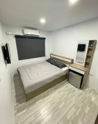 a small bedroom with a bed and a tv at Garden Beach Sea View Patong in Patong Beach