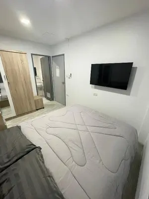 a white room with a bed and a flat screen tv at Garden Beach Sea View Patong in Patong Beach