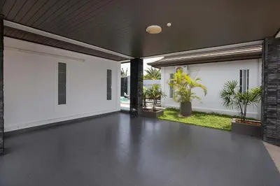an empty patio with white walls and potted plants at 3BR Villa Marine with Private Pool, Waterfalls in NaiHarn Beach in Rawai Beach