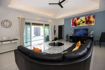 a living room with a leather couch and a tv at 3BR Villa Marine with Private Pool, Waterfalls in NaiHarn Beach in Rawai Beach