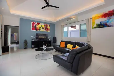 a living room with a leather couch and a table at 3BR Villa Marine with Private Pool, Waterfalls in NaiHarn Beach in Rawai Beach