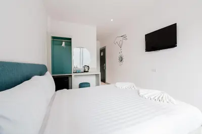 a bedroom with a white bed and a flat screen tv at Moon Budget Hotel in Ao Nang Beach