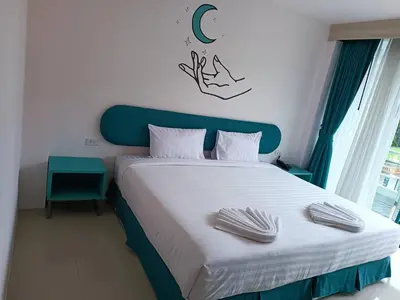 a bedroom with a large bed with a blue headboard at Moon Budget Hotel in Ao Nang Beach