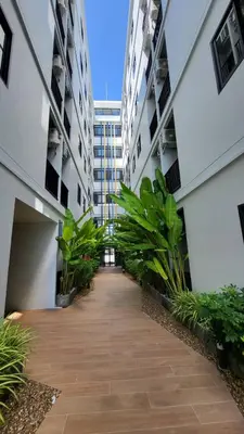 an empty hallway between two buildings with plants at VIP Great Hill Phuket Airport in Phuket Town
