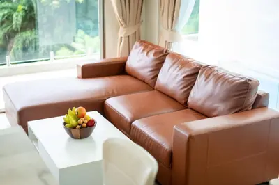 a brown leather couch in a living room with a table at seaview villa private swimming pool in Karon Beach