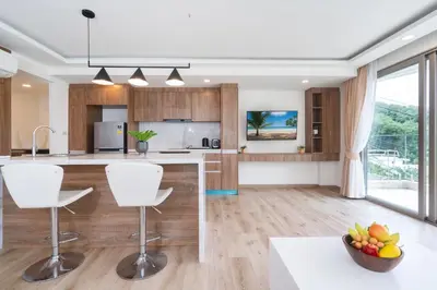 a kitchen with wooden cabinets and white appliances at seaview villa private swimming pool in Karon Beach