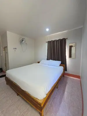 a bedroom with a large white bed in a room at TR Bungalow in Ban Tha Rua