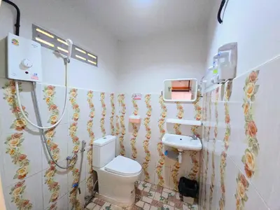 a bathroom with a toilet and a sink at TR Bungalow in Ban Tha Rua