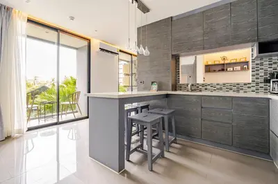 a kitchen with a counter and stools in it at CityGate by Villacarte in Kamala Beach