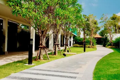 a walkway in front of a house with trees at White Lotus by Oxygen at Bang Tao Beach in Ban Thalat Choeng Thale