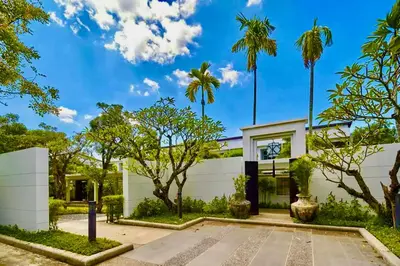 a house with palm trees in front of it at White Lotus by Oxygen at Bang Tao Beach in Ban Thalat Choeng Thale